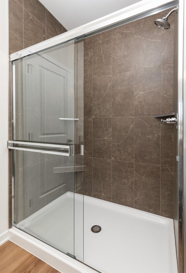 7011 Lincoln Cir, Johnston, IA 50131 - bathroom featuring a shower stall and wood finished floors