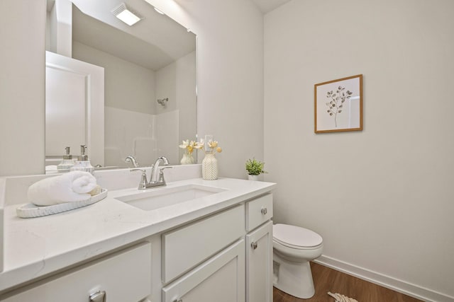 bathroom featuring a shower, wood-type flooring, vanity, and toilet