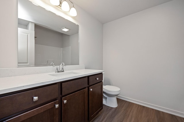 bathroom with hardwood / wood-style flooring, vanity, toilet, and walk in shower