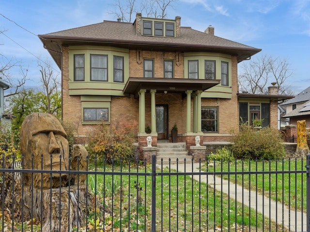 1080 31st St, Des Moines, IA 50311 - view of front facade with a shingled roof, a chimney, a fenced front yard, brick siding, and a front lawn