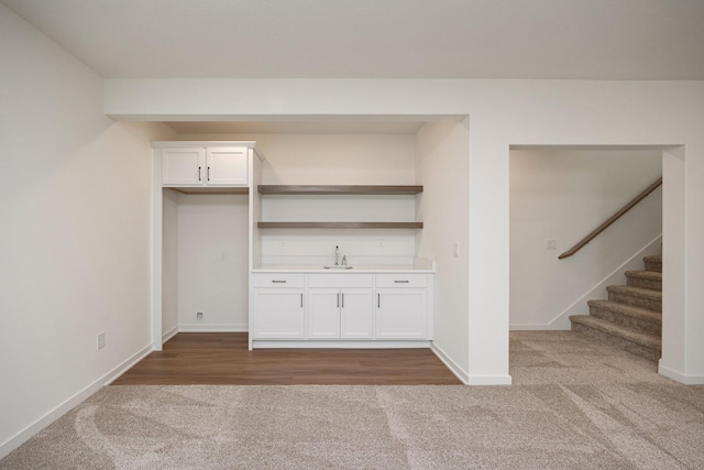 8916 Beery Pl, Johnston, IA 50131 - indoor wet bar featuring carpet floors, baseboards, and stairway