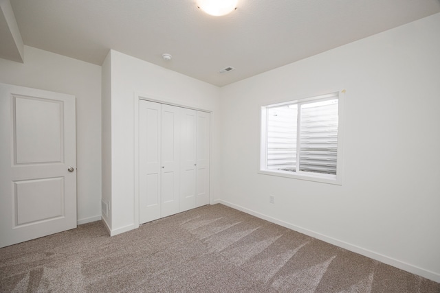 unfurnished bedroom featuring carpet flooring and a closet