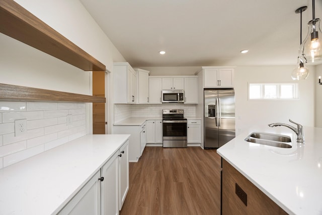 8916 Beery Pl, Johnston, IA 50131 - kitchen with appliances with stainless steel finishes, a sink, backsplash, dark wood-style floors, and white cabinetry