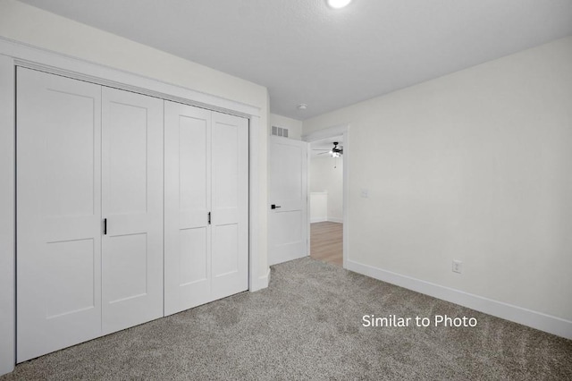 unfurnished bedroom with carpet flooring and a closet