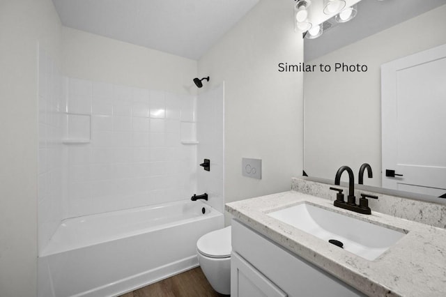 full bathroom with hardwood / wood-style floors, vanity, shower / bathtub combination, and toilet