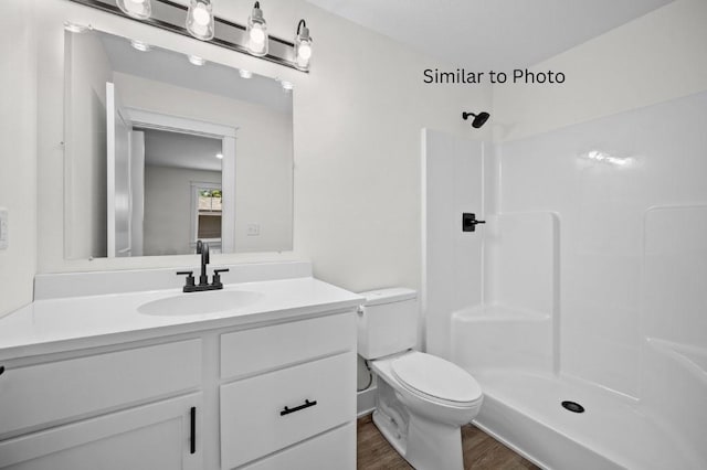 bathroom with a shower, vanity, wood-type flooring, and toilet