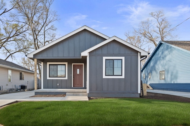 2505 Shaw St, Des Moines, IA 50317 - view of front of house with board and batten siding, a front lawn, and covered porch