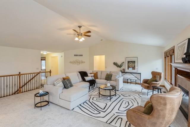 carpeted living room featuring a fireplace, vaulted ceiling, and ceiling fan