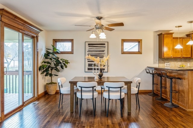 dining area with ceiling fan and dark wood-type flooring