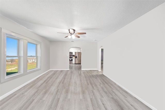 unfurnished room featuring ceiling fan, a textured ceiling, and light hardwood / wood-style floors