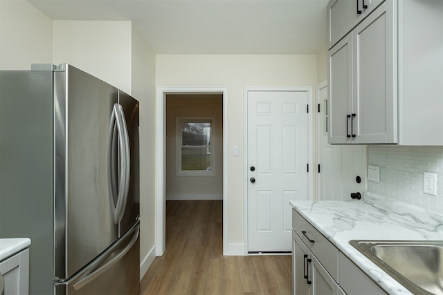 kitchen featuring gray cabinets, stainless steel fridge, and light hardwood / wood-style flooring