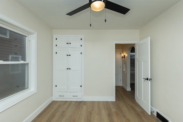 unfurnished bedroom with a closet, light hardwood / wood-style flooring, and ceiling fan