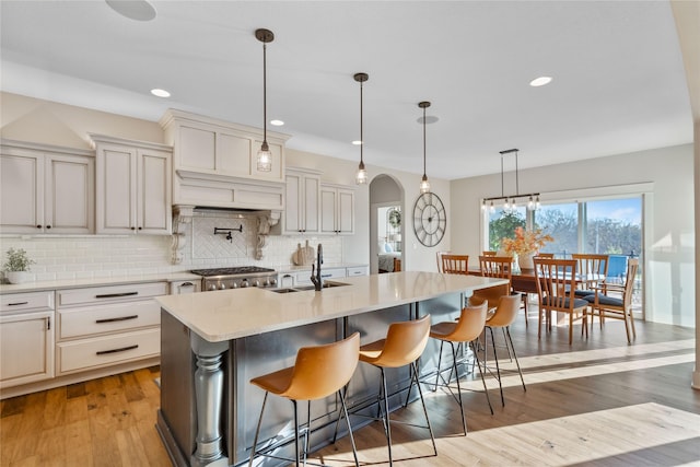 kitchen featuring pendant lighting, a breakfast bar, and an island with sink