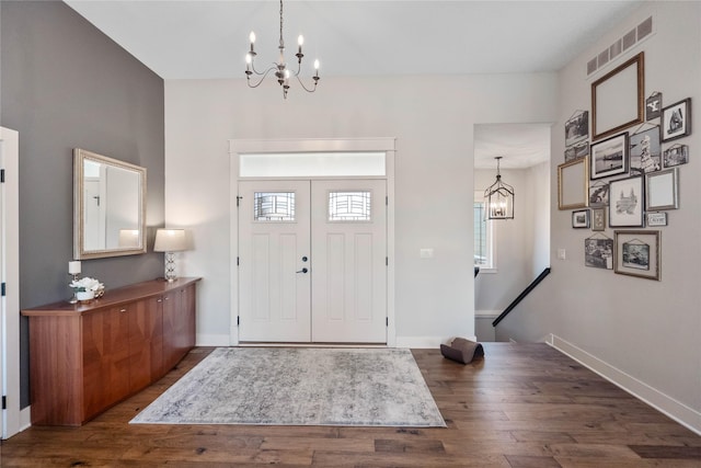 entrance foyer featuring dark wood-type flooring and an inviting chandelier