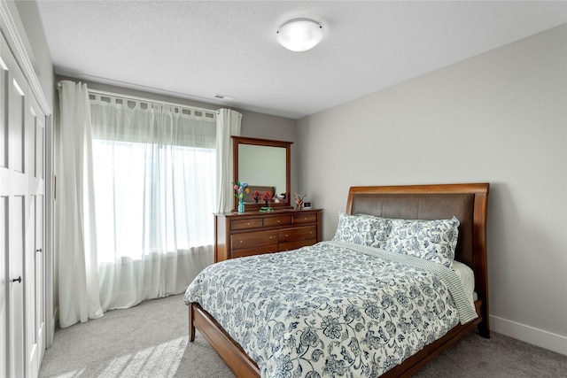 bedroom with light carpet and multiple windows