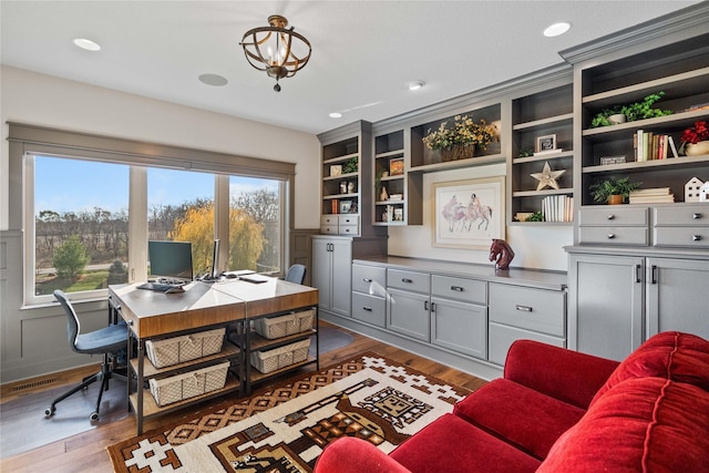 home office with dark wood-type flooring, built in features, and a notable chandelier