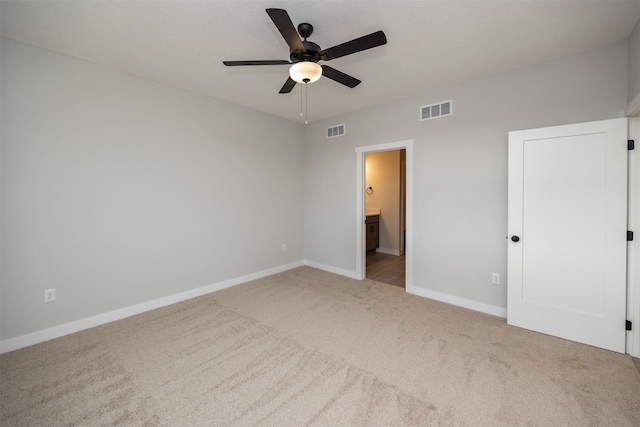 unfurnished bedroom with ensuite bathroom, ceiling fan, and light carpet