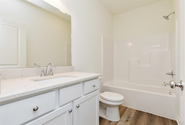 full bathroom with hardwood / wood-style floors, vanity, shower / bathtub combination, and toilet