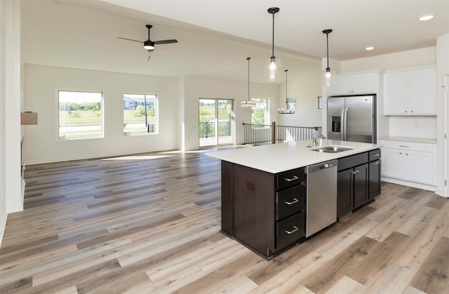 kitchen featuring ceiling fan, plenty of natural light, stainless steel appliances, and a center island with sink