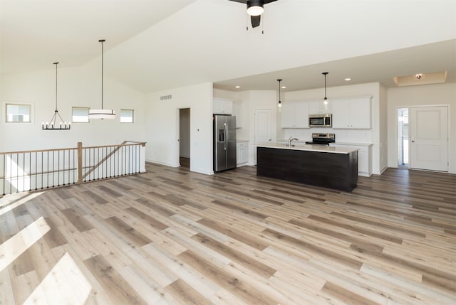 kitchen featuring white cabinets, sink, an island with sink, light hardwood / wood-style floors, and stainless steel appliances