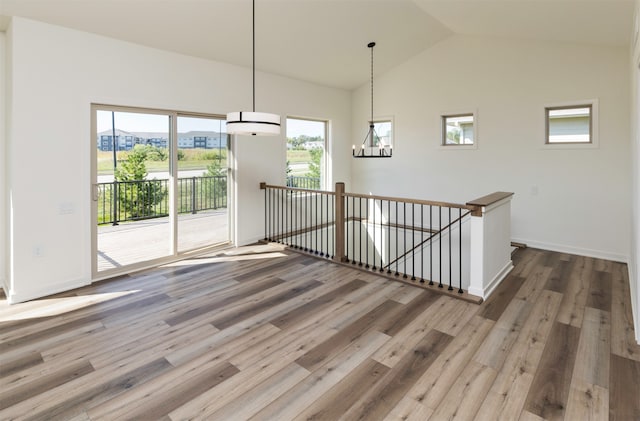 interior space featuring a chandelier, wood-type flooring, and lofted ceiling