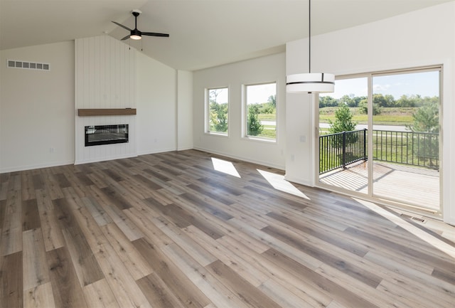 unfurnished living room with ceiling fan, a fireplace, wood-type flooring, and vaulted ceiling