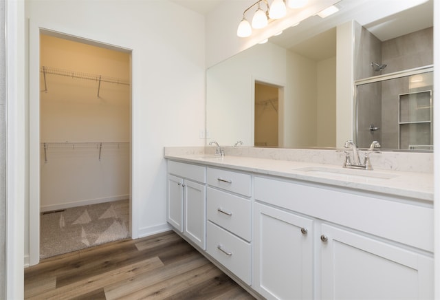 bathroom featuring vanity, wood-type flooring, and an enclosed shower