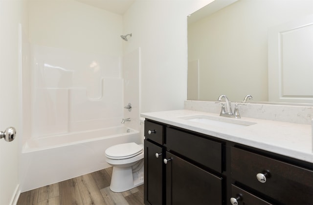 full bathroom with washtub / shower combination, hardwood / wood-style floors, vanity, and toilet