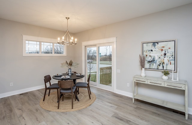 dining room featuring light wood-type flooring and a chandelier