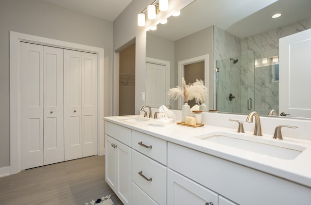 bathroom featuring vanity, wood-type flooring, and a shower with shower door