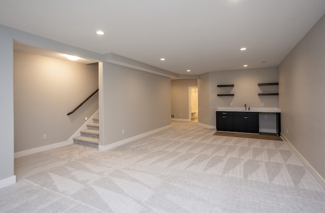 unfurnished living room with indoor wet bar and light colored carpet