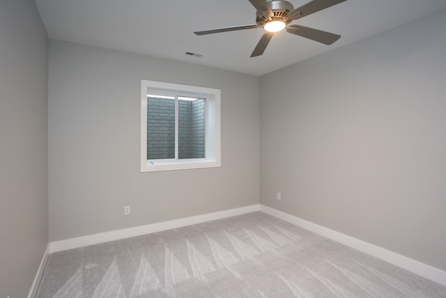 empty room with ceiling fan and light carpet