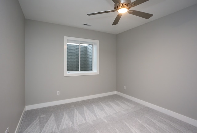 spare room with ceiling fan and light colored carpet