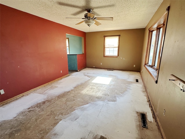 empty room with a textured ceiling and ceiling fan