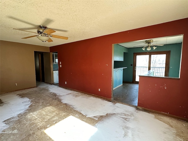 unfurnished room featuring baseboards, a ceiling fan, and a textured ceiling