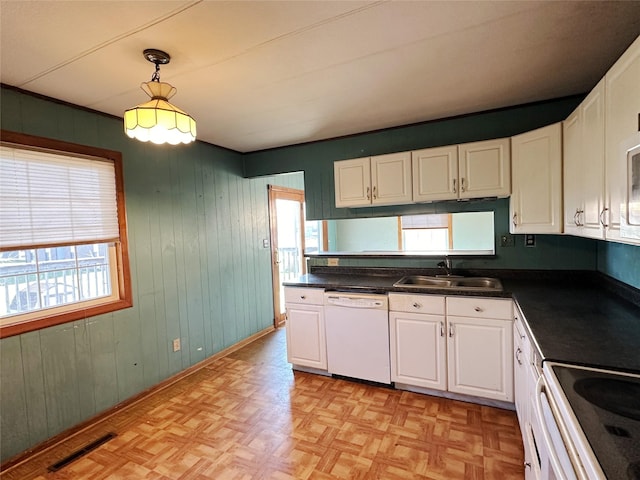 kitchen featuring white dishwasher, a sink, visible vents, and white cabinets