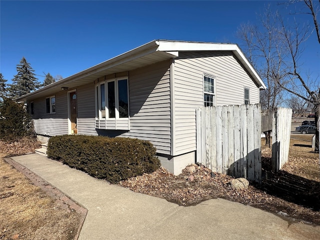 view of side of home featuring fence