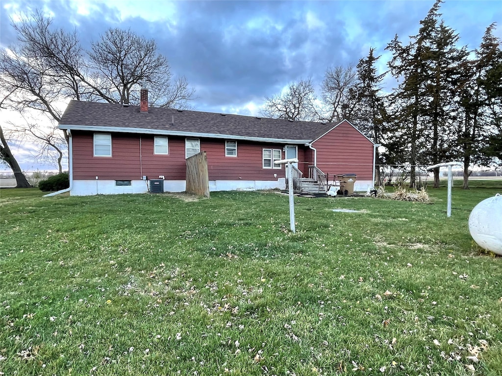 back of property featuring a lawn and cooling unit