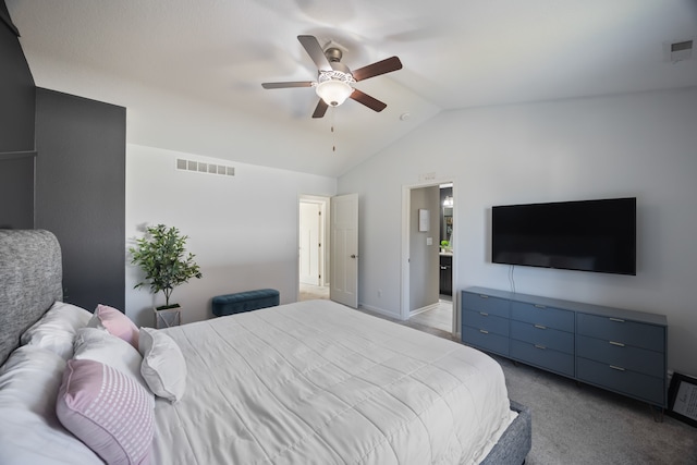 carpeted bedroom with ceiling fan, lofted ceiling, and ensuite bathroom