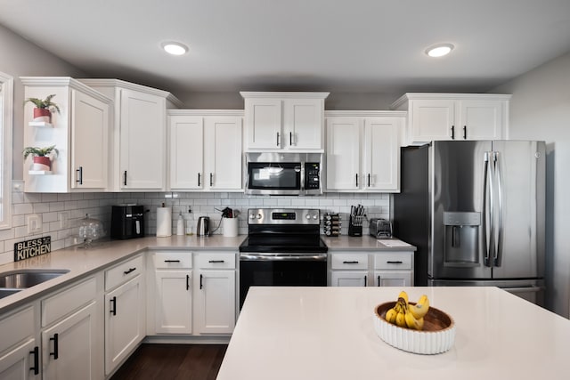 kitchen featuring backsplash, white cabinetry, dark hardwood / wood-style floors, and appliances with stainless steel finishes