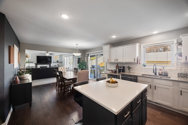 kitchen with white cabinets, a kitchen island, and sink