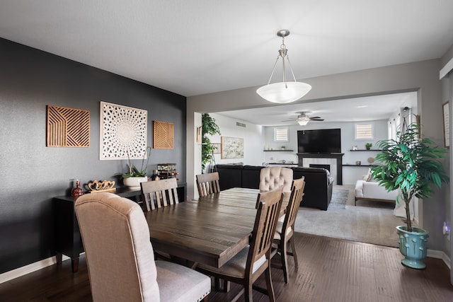 dining area with ceiling fan and dark wood-type flooring