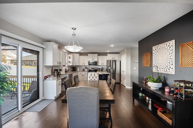 dining room featuring a textured ceiling, dark hardwood / wood-style floors, and sink