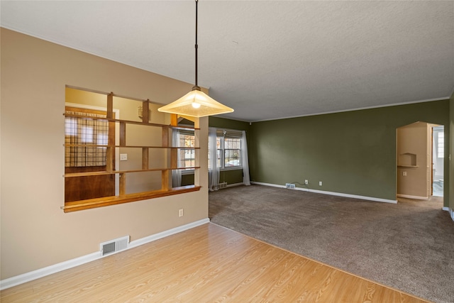 interior space featuring ornamental molding, a textured ceiling, and hardwood / wood-style flooring