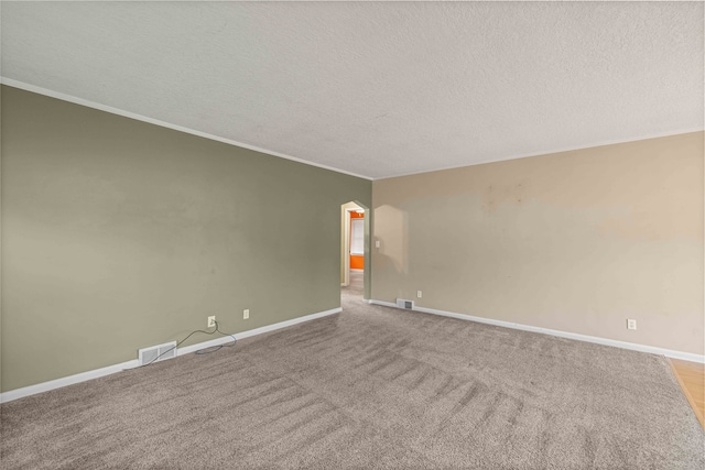 empty room featuring a textured ceiling, ornamental molding, and light carpet