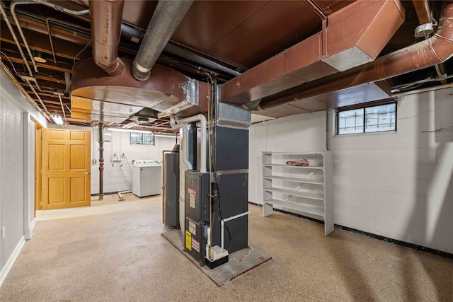 basement featuring water heater, separate washer and dryer, and heating unit