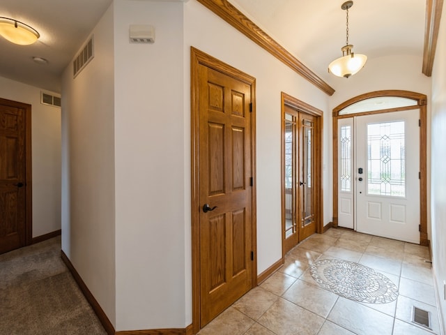 tiled entryway featuring ornamental molding