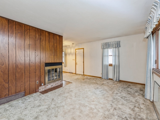 unfurnished living room with light colored carpet and wooden walls