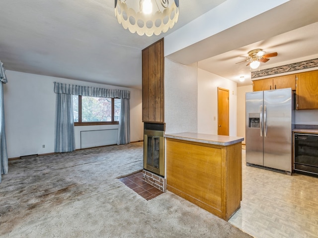 kitchen featuring kitchen peninsula, stainless steel fridge, light colored carpet, and dishwasher