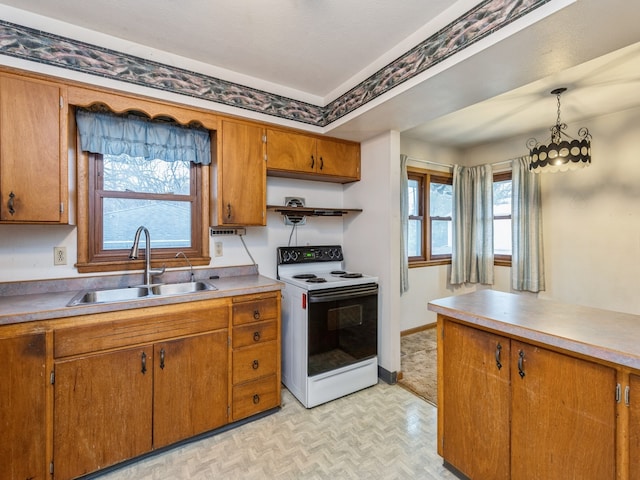 kitchen featuring light parquet flooring, white electric stove, hanging light fixtures, and sink